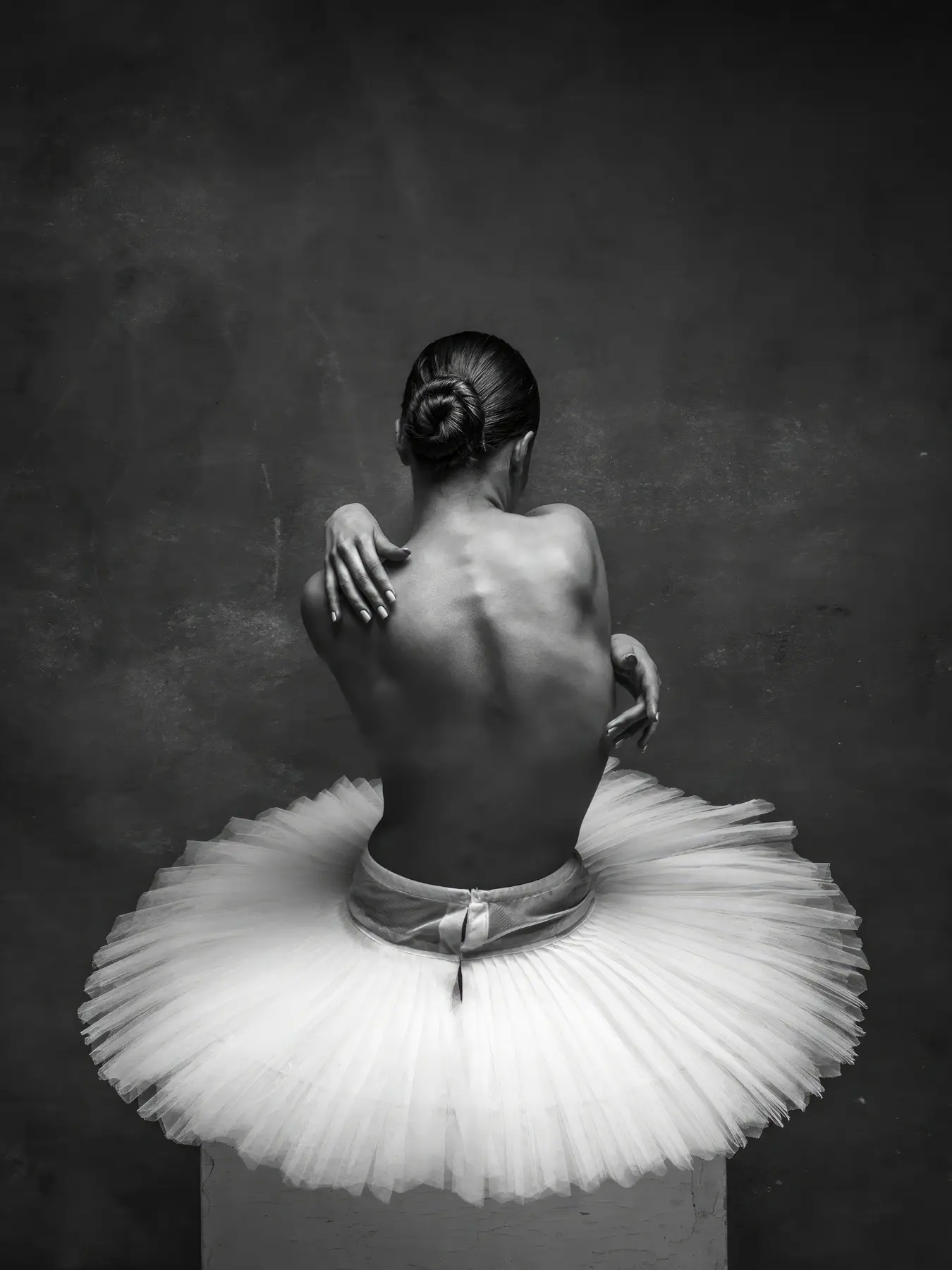 Dos de ballerine en tutu blanc sur fond sombre texturé
