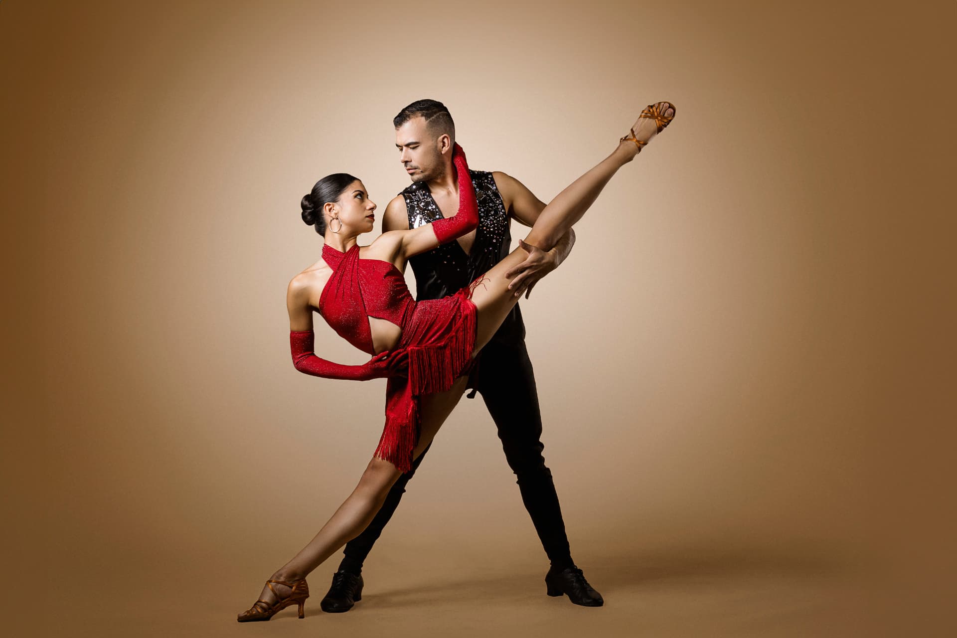 Couple de danseurs latins en performance, robe rouge à franges