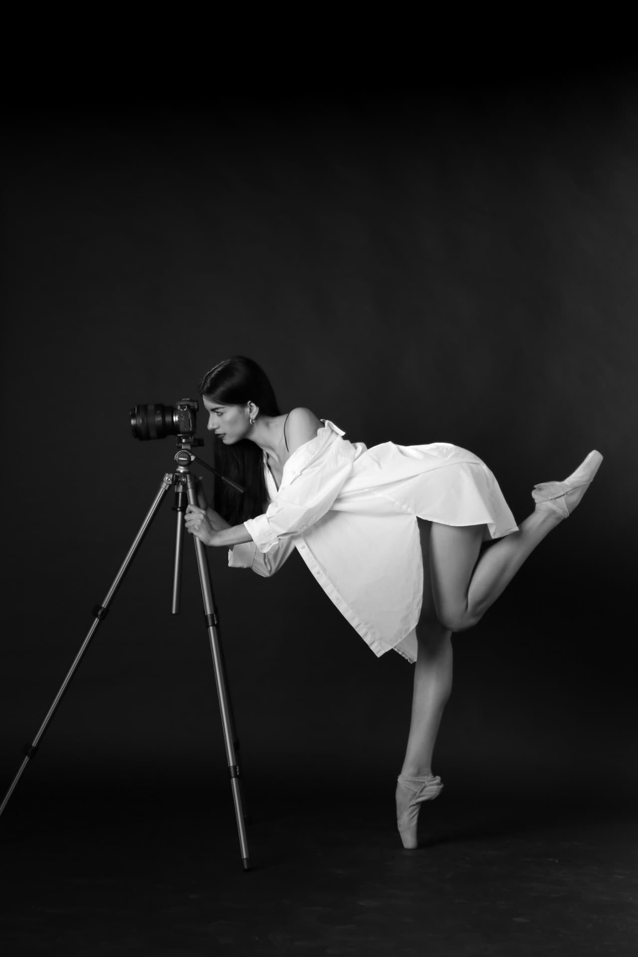Danseuse sur pointes penchée sur un appareil photo, noir et blanc