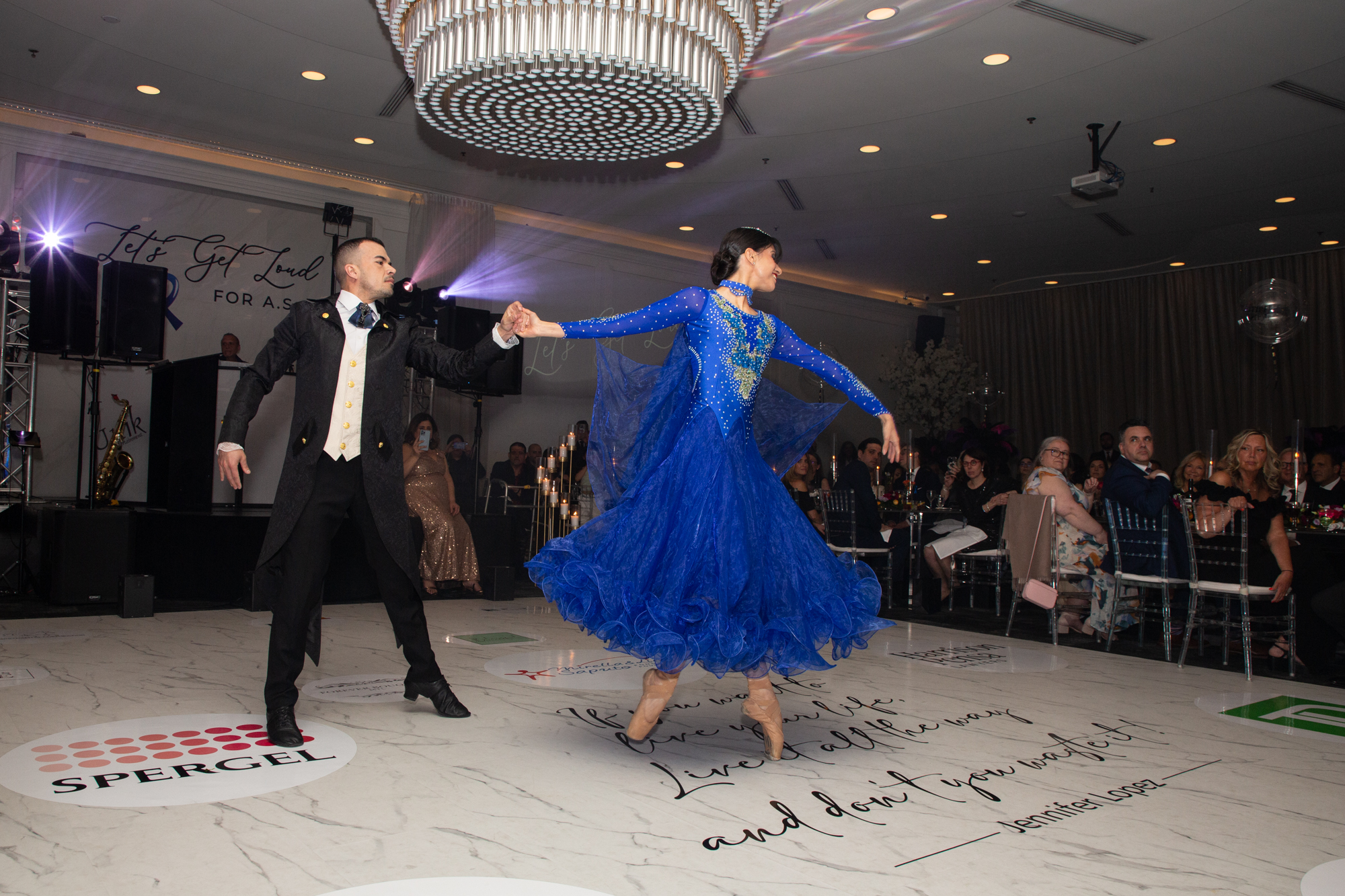 Couple de danse de salon en robe bleue devant les invités d'un gala