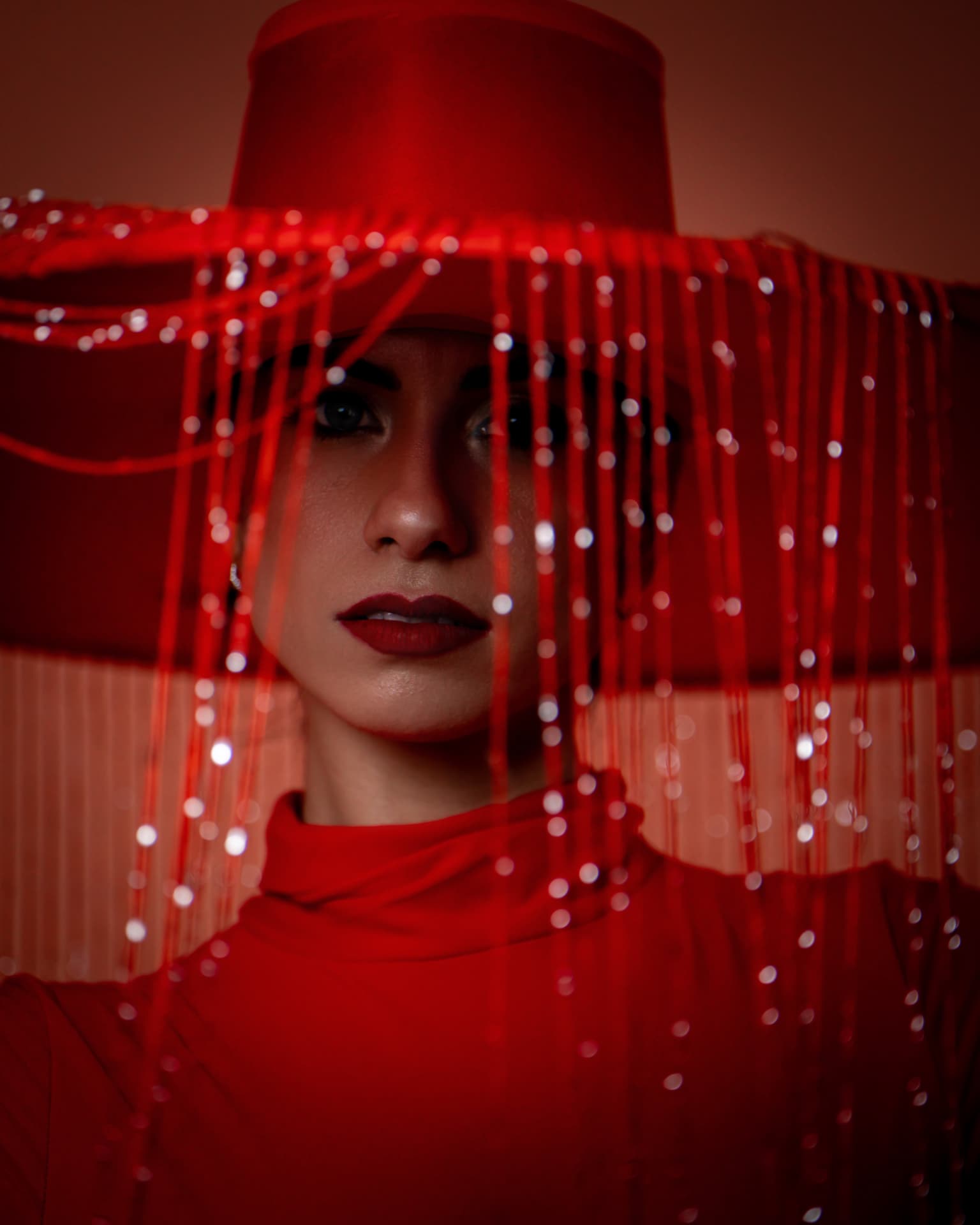 Portrait rapproché sous un chapeau rouge à franges perlées