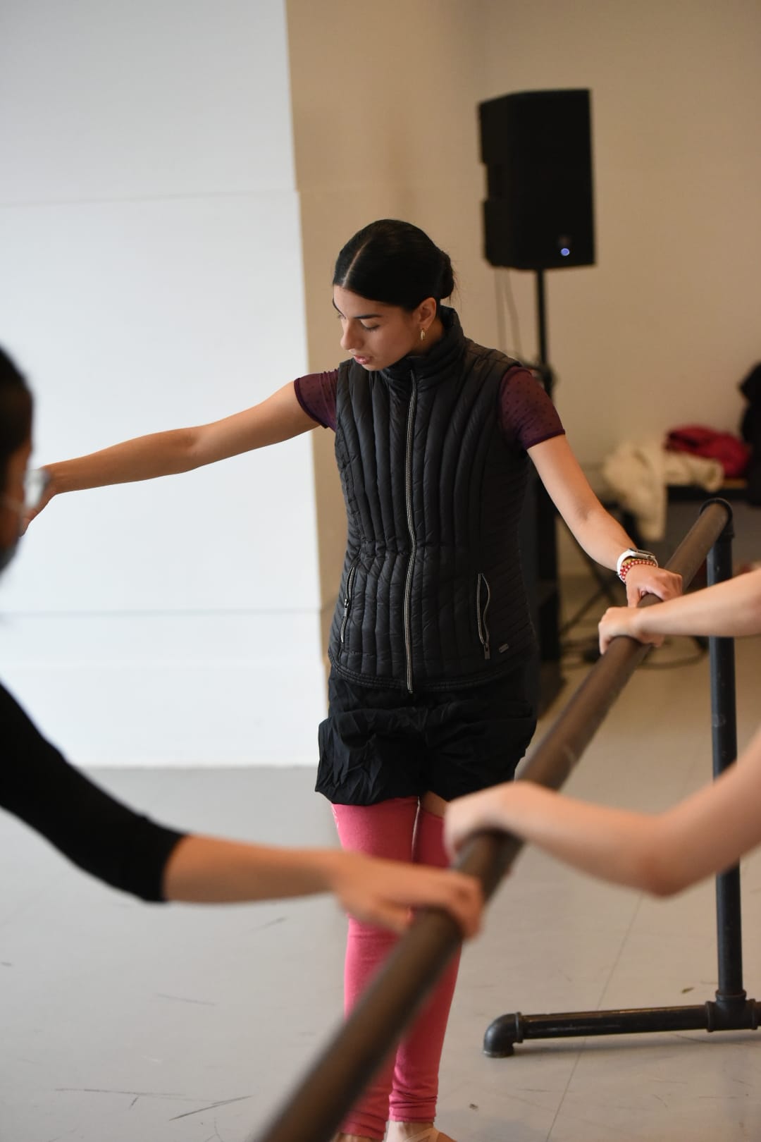 Jeune danseuse à la barre pendant un cours de danse en studio
