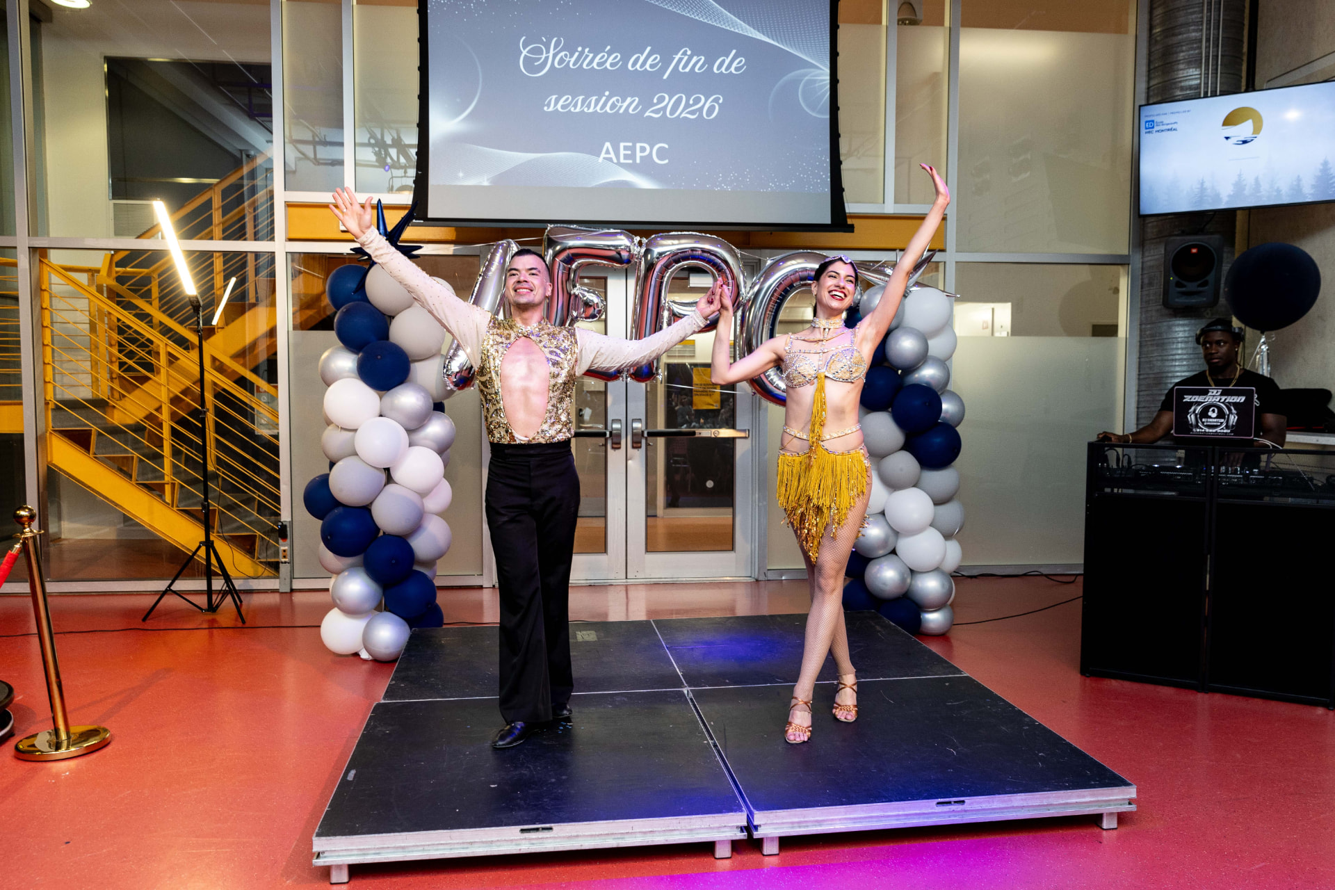 Duo de danseurs en costumes dorés saluant sur scène lors d'une soirée corporative
