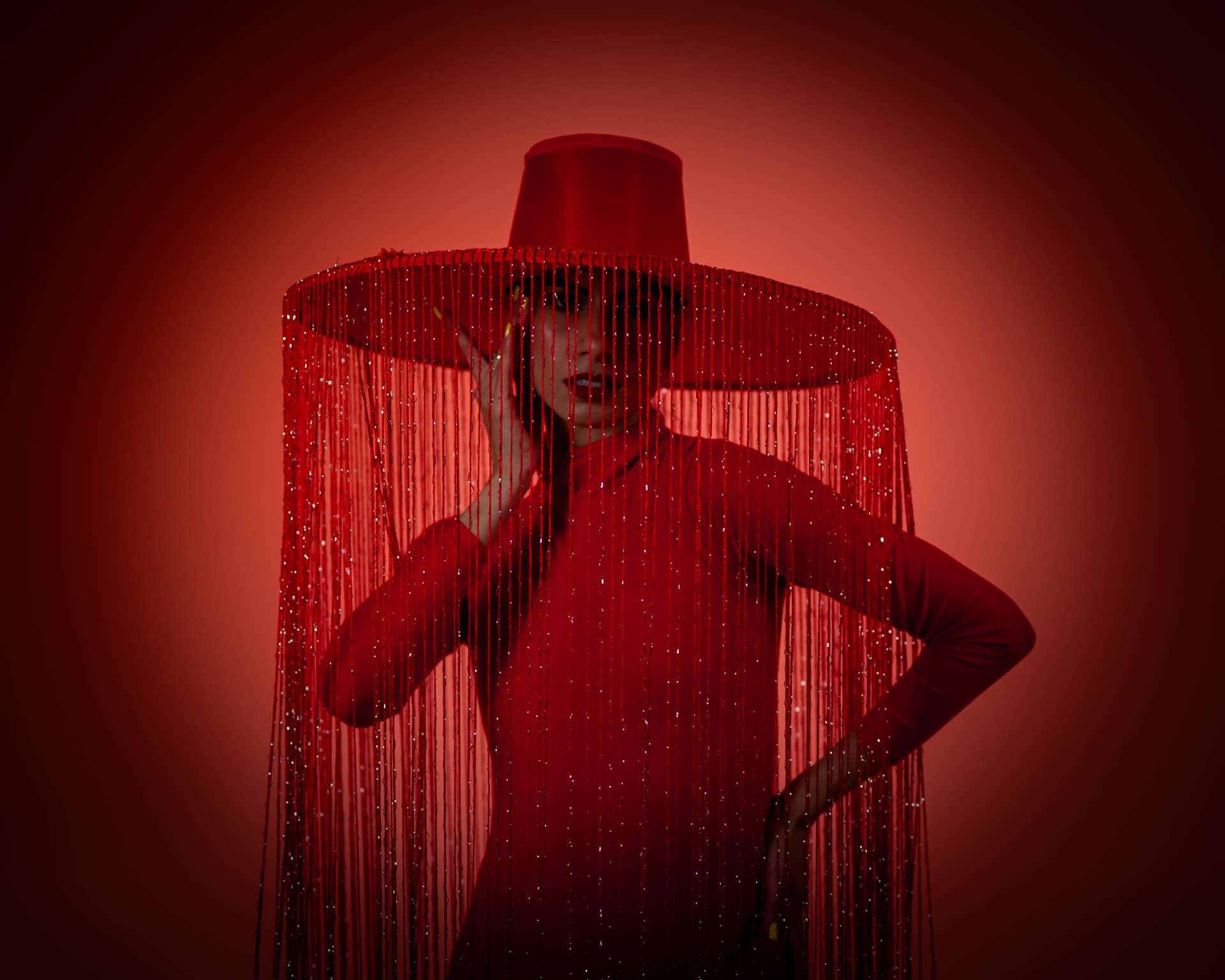 Silhouette sous un immense chapeau à franges perlées rouges