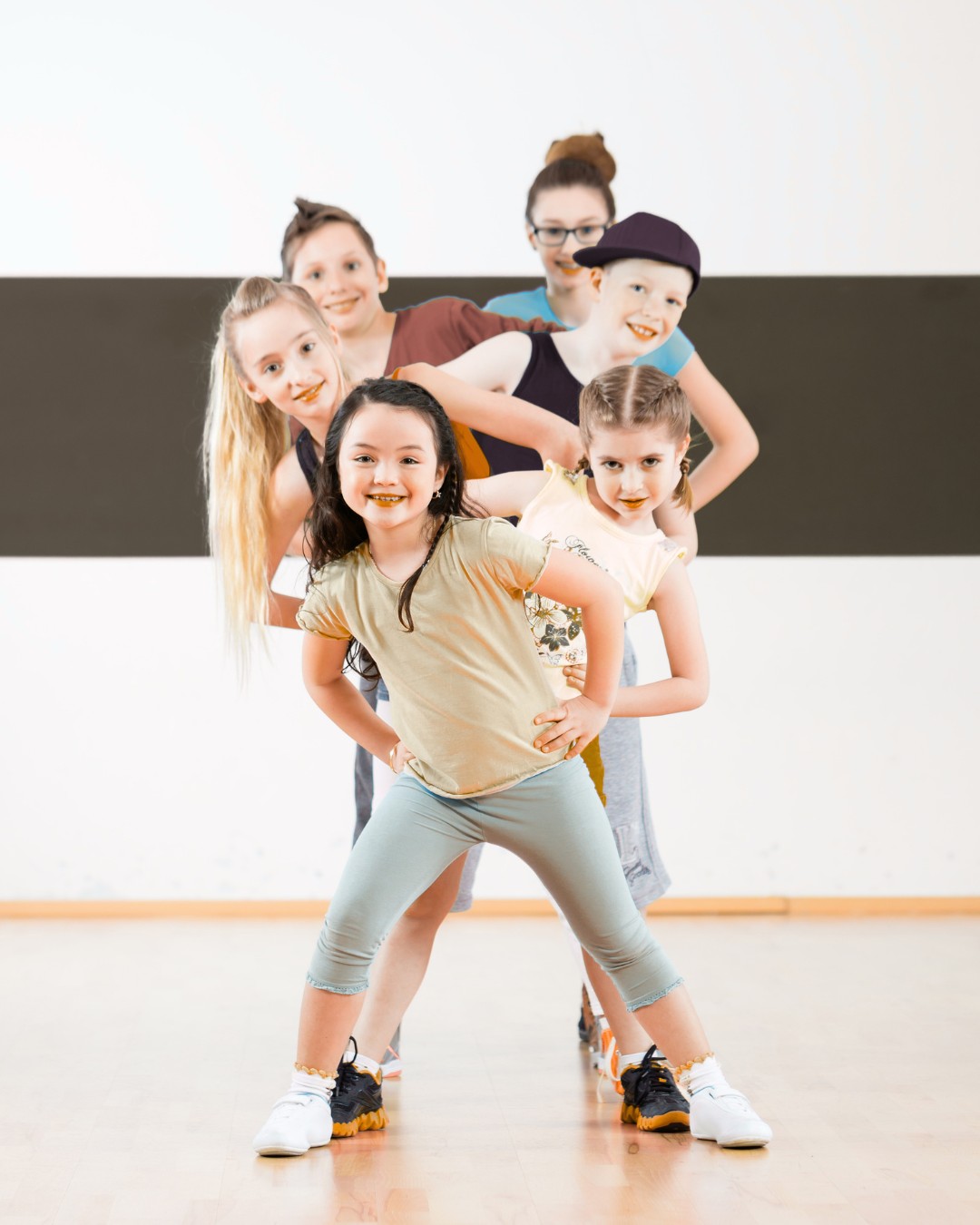 Groupe d'enfants dansant en studio, souriants et pleins d'énergie