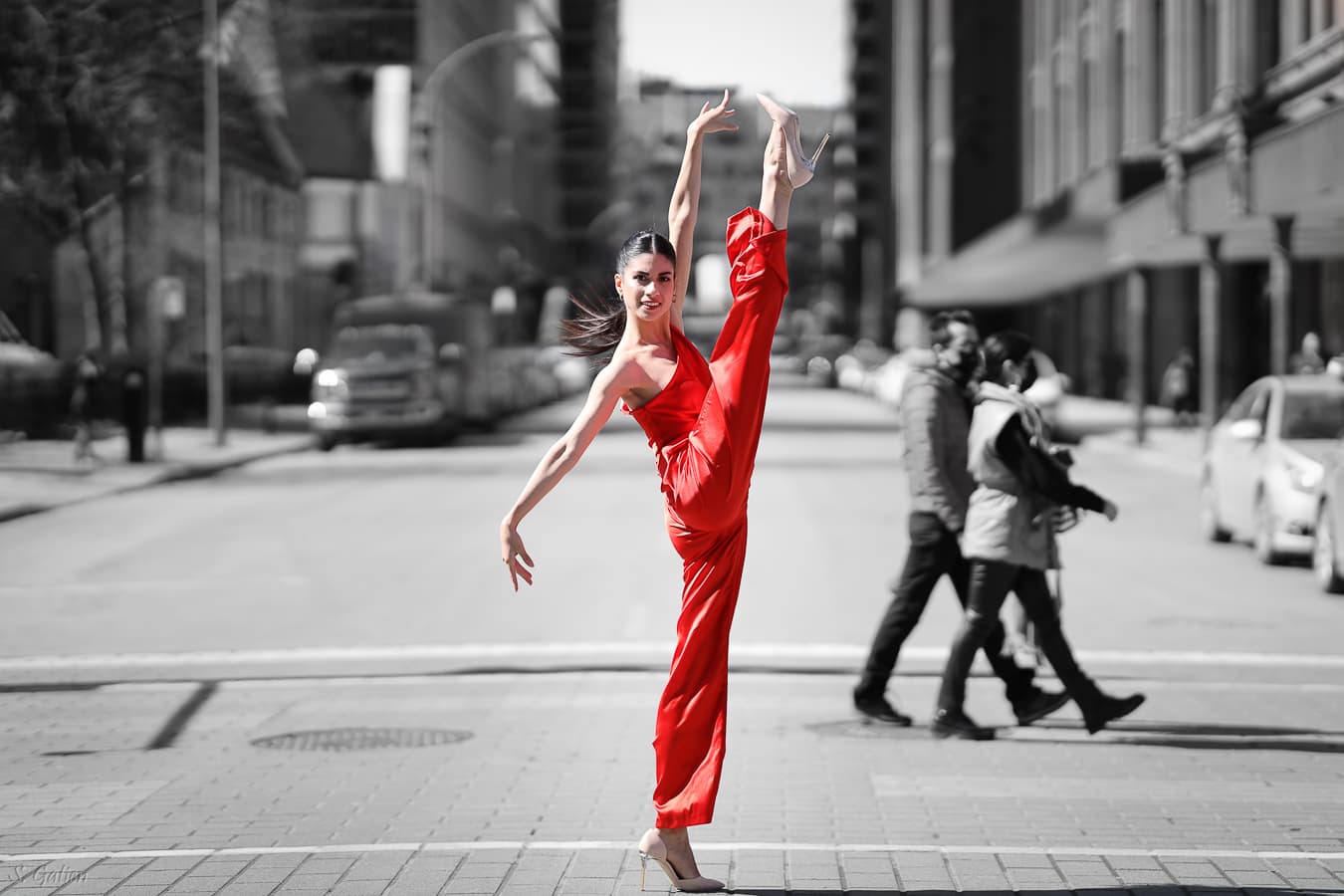 Danseuse en robe rouge, grand écart vertical dans une rue de Montréal