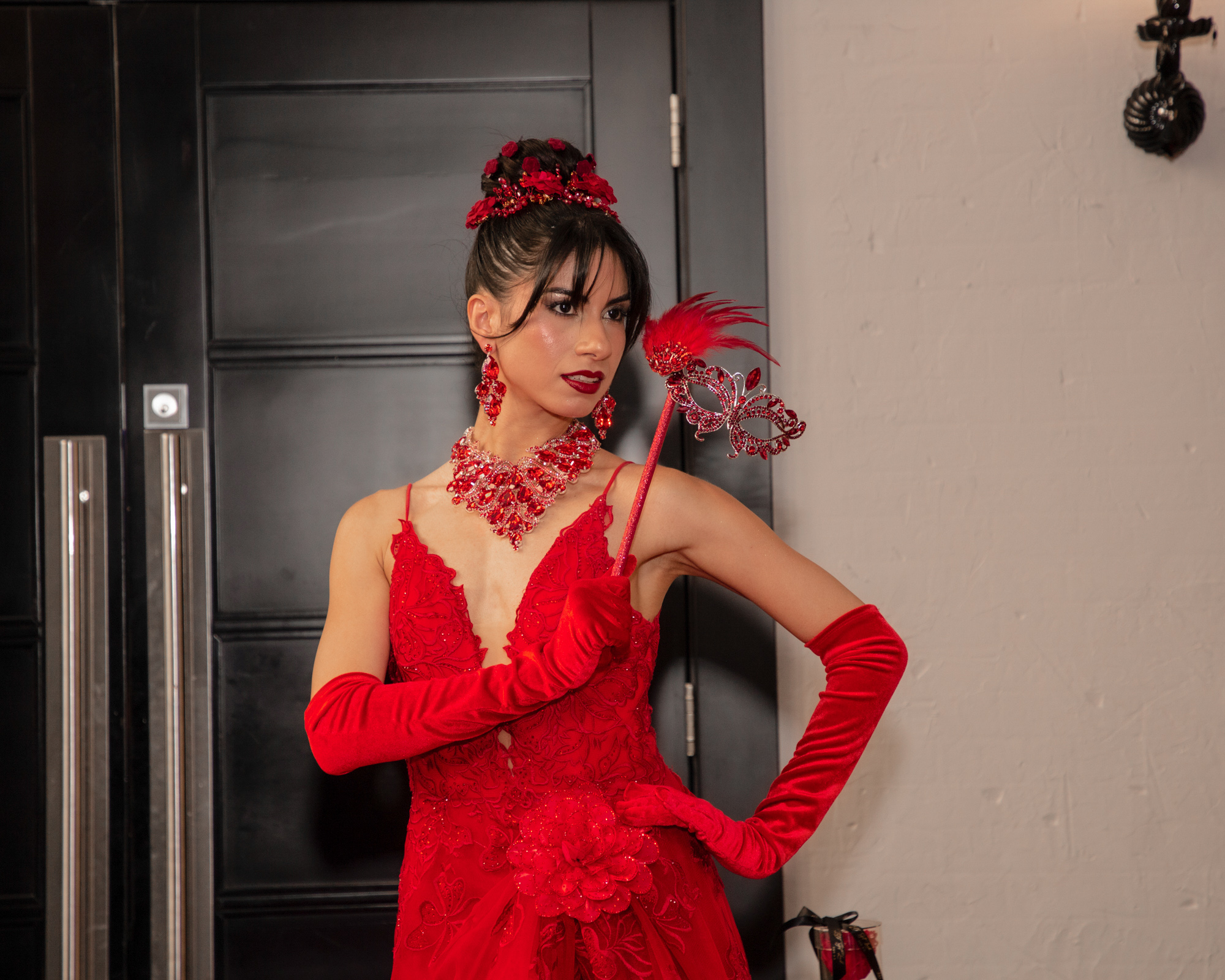 Maîtresse de cérémonie en robe rouge et masque orné lors d'un gala